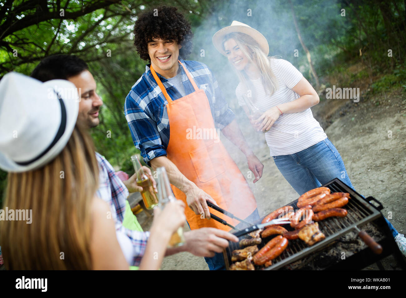 Group of happy friends having a barbecue party in nature Stock Photo ...