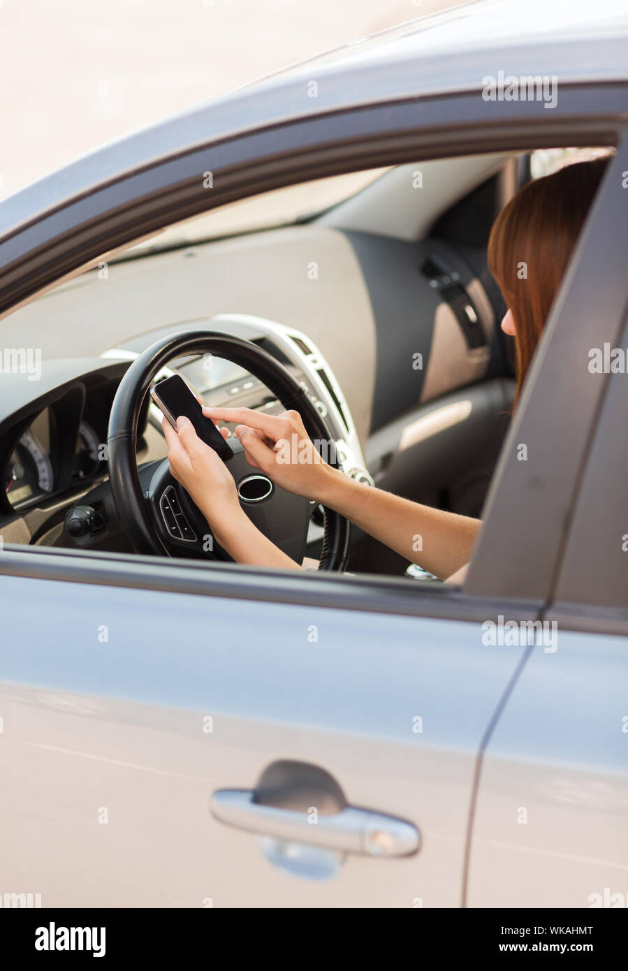 woman using phone while driving the car Stock Photo