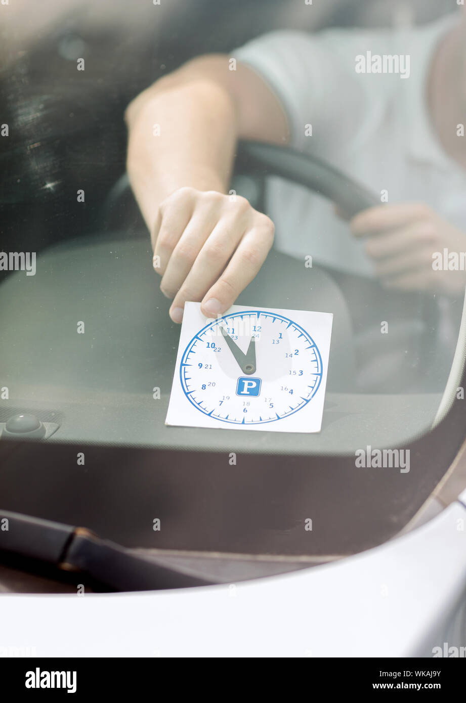 man placing parking clock on car dashboard Stock Photo Alamy