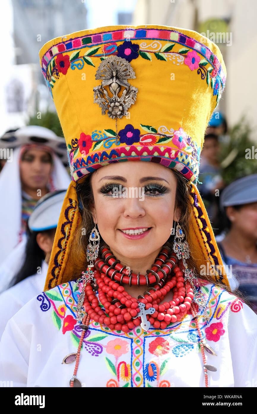 A woman wears a colourful headdress as residents of Quito in Ecuador march through the city's historic centre on the morning of Palm Sunday. The colou Stock Photo