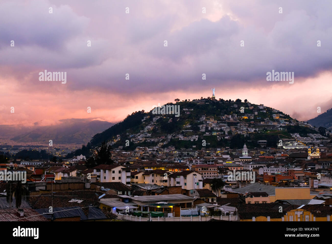 The sun sets over El Panecillo in Quito in Ecuador. Also known as the Virgin of the Apocalypse, Winged Virgin of Quito, Dancing Madonna, and Legarda's Stock Photo