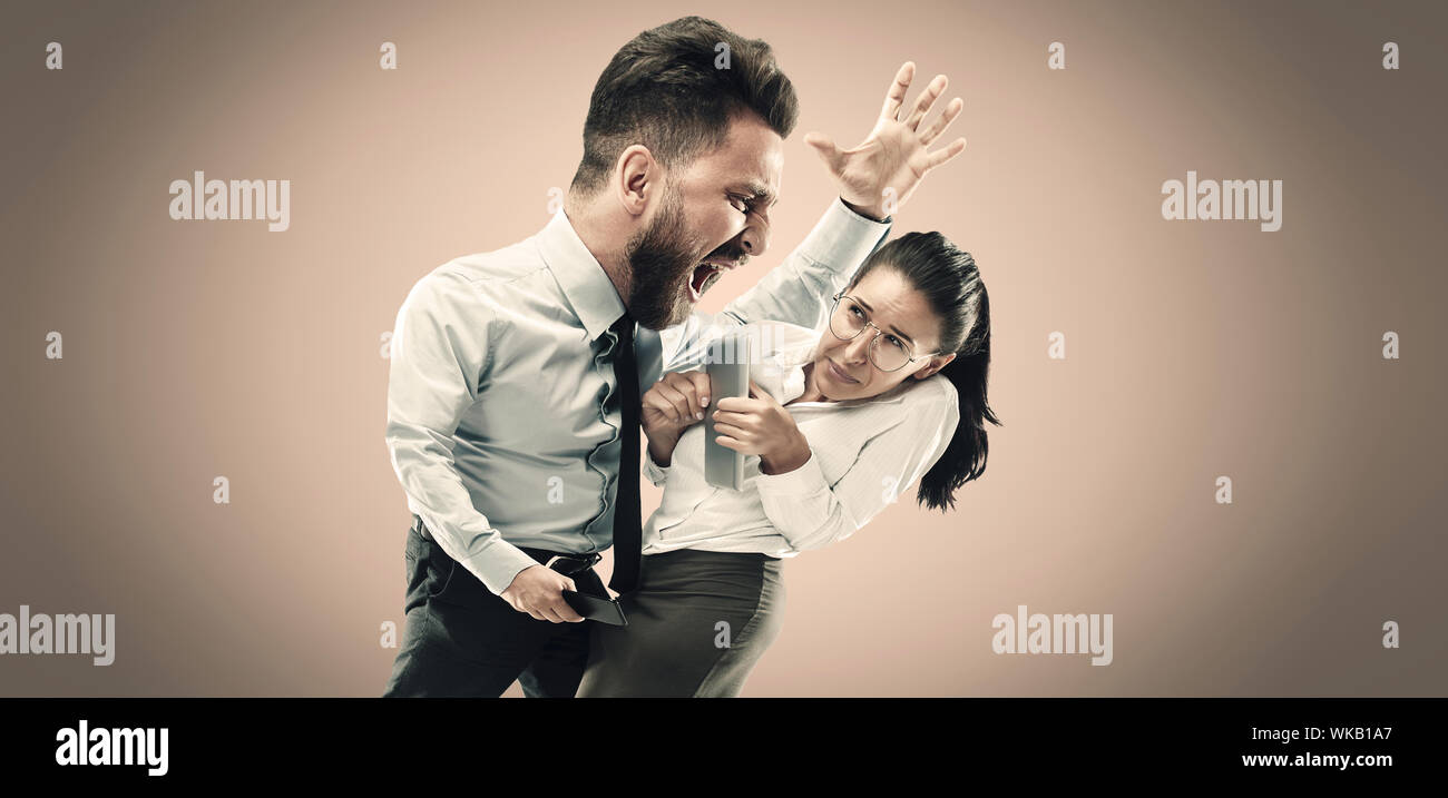 Angry businessman screaming at employee in the office. Caucasian woman is under the pressure and agressia from her boss. Office work and problem, corporate, business concept. Stock Photo