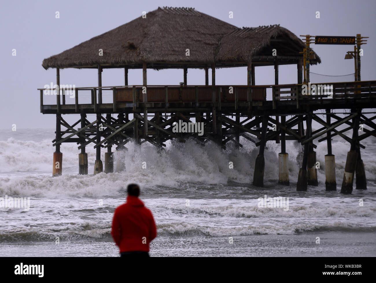 Cocoa Beach, United States. 03rd Sep, 2019. A man watches as strong waves crash into the Cocoa Beach Pier as Hurricane Dorian turns to the north off the eastern coast of Florida after a weakened Category 2 storm devastates parts of the Bahamas. Credit: SOPA Images Limited/Alamy Live News Stock Photo