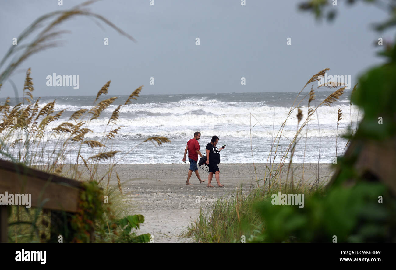Cocoa Beach, United States. 03rd Sep, 2019. A couple walks along the beach as Hurricane Dorian brings heavy surf and wind as it turns to the north off the eastern coast of Florida after a weakened Category 2 storm devastates parts of the Bahamas. Credit: SOPA Images Limited/Alamy Live News Stock Photo