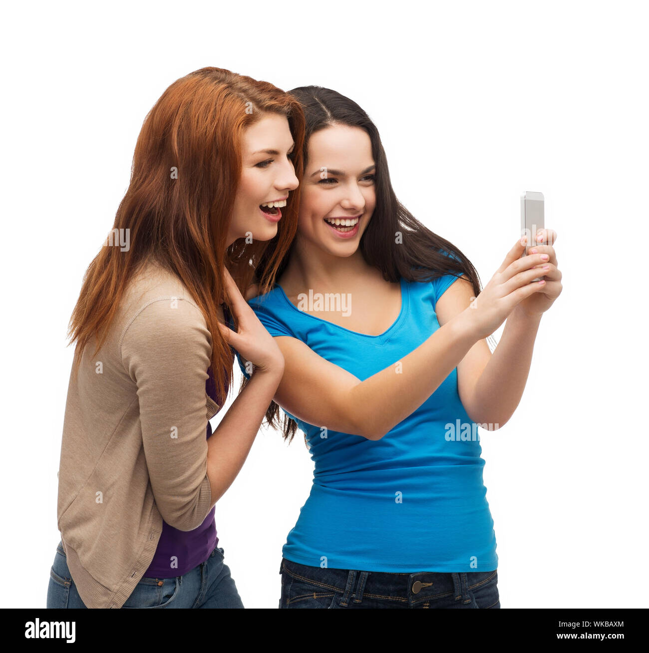 technology, friendship and people concept - two smiling teenagers with smartphone Stock Photo