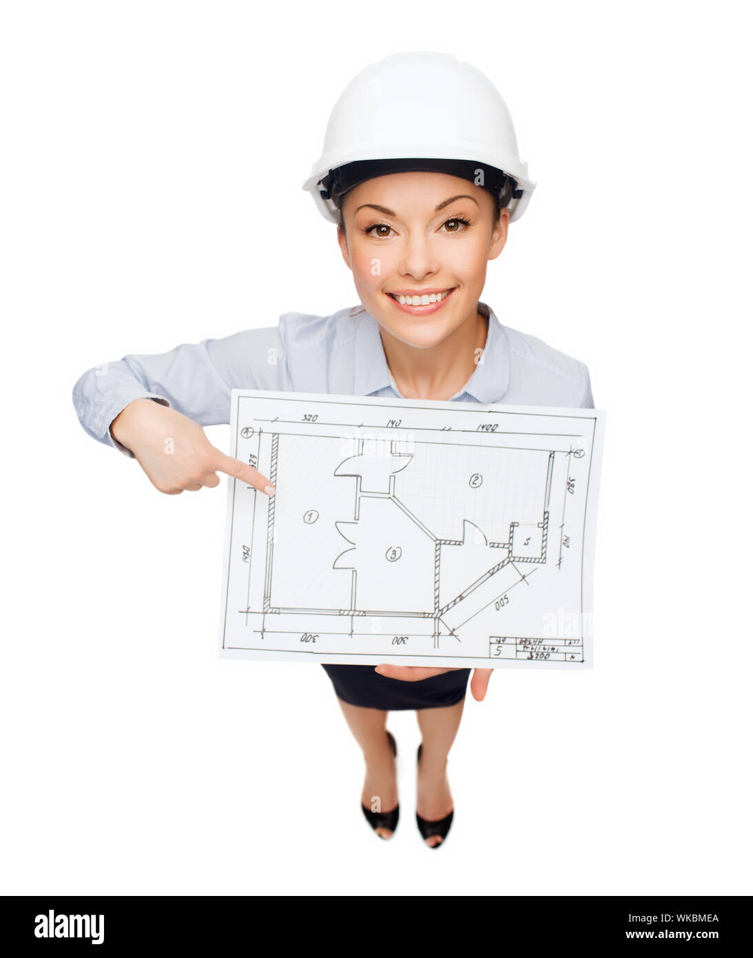 building, developing, consrtuction and architecture concept - smiling businesswoman in white helmet pointing finger to blueprint Stock Photo