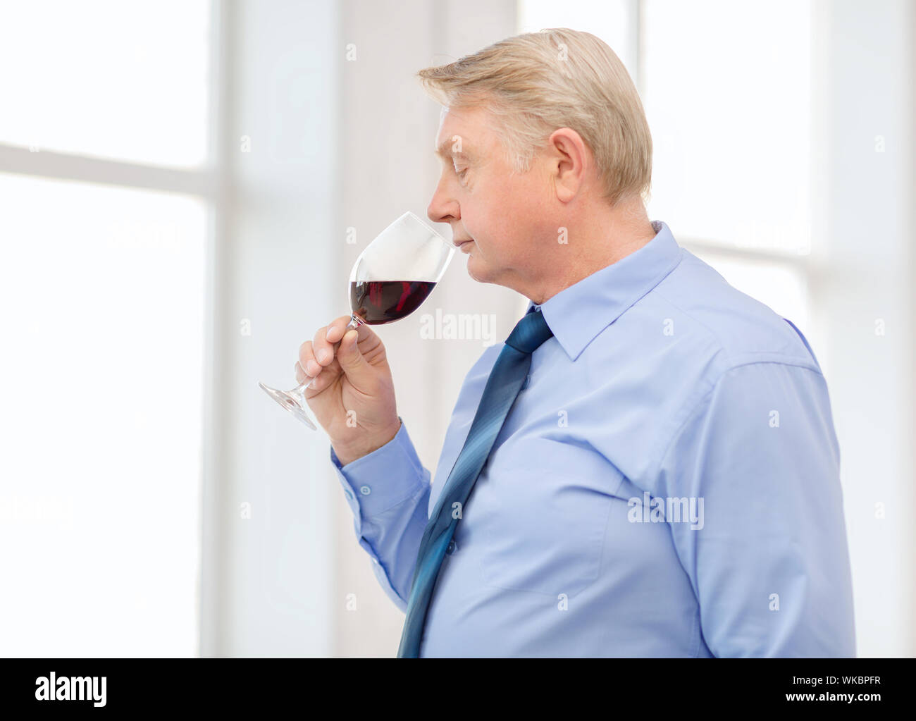 older man smelling red wine Stock Photo - Alamy