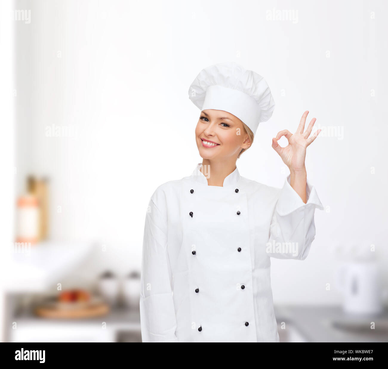 smiling female chef showing ok hand sign Stock Photo - Alamy