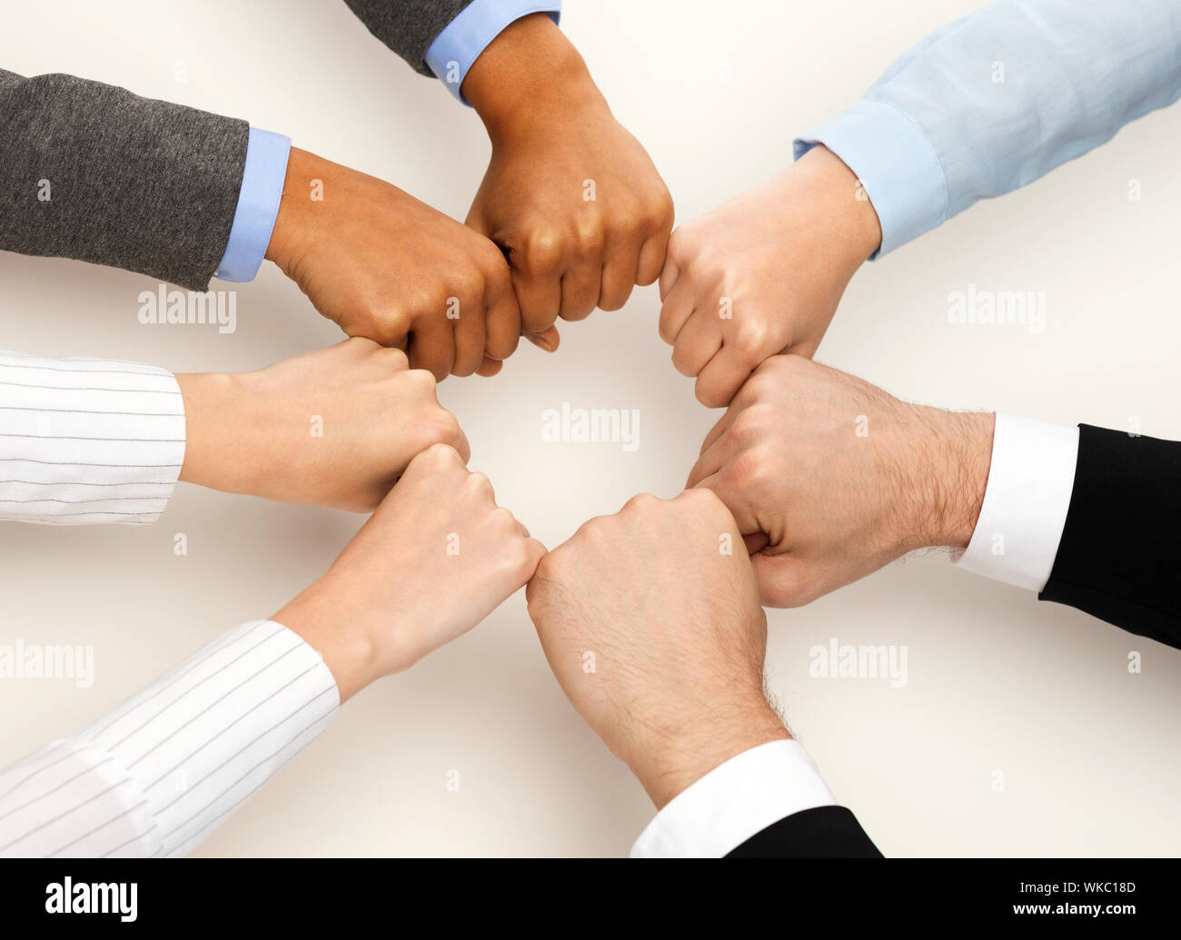 business and teamwork concept - closeup of businesspeople hands in fists in circle Stock Photo