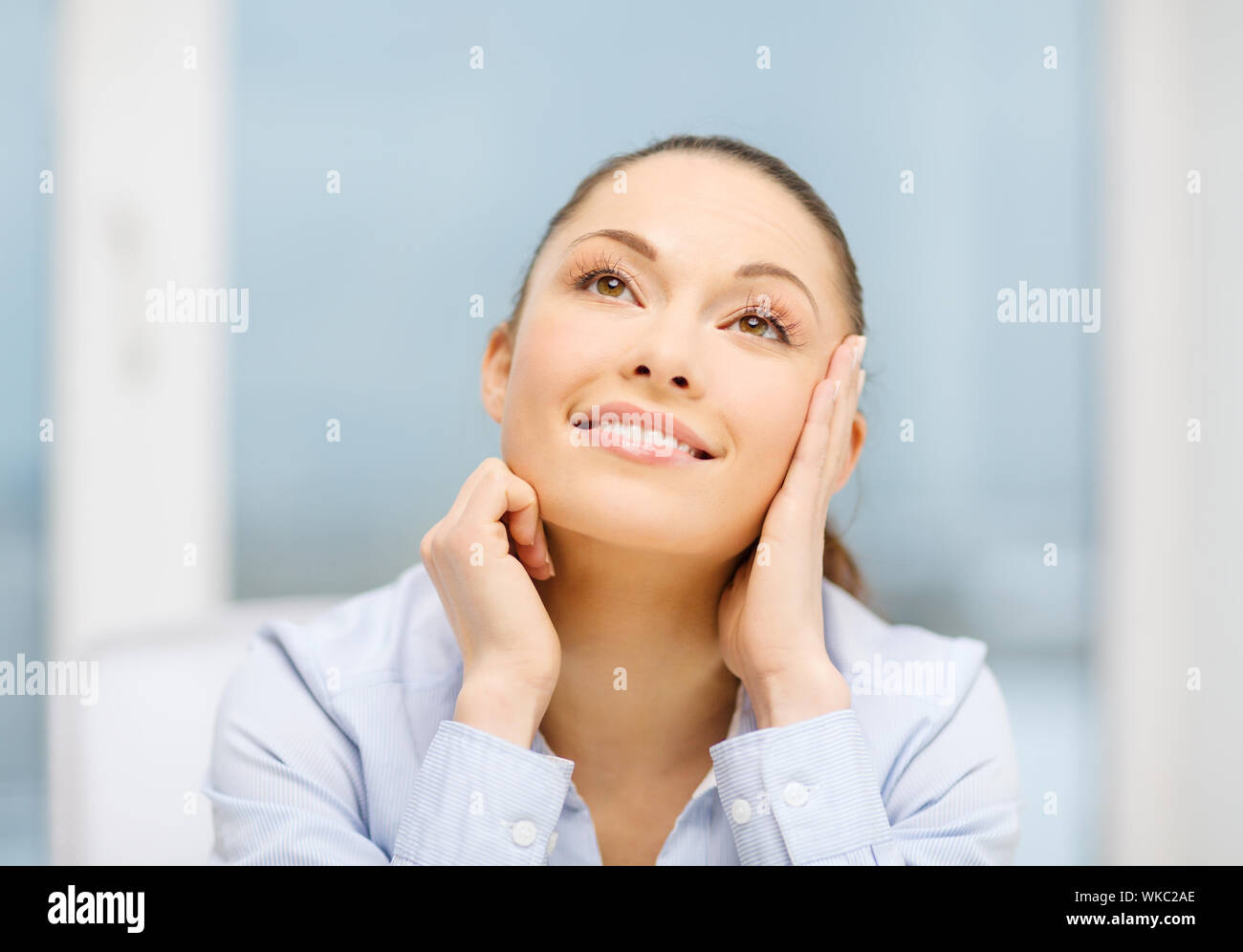 smiling businesswoman dreaming in office Stock Photo