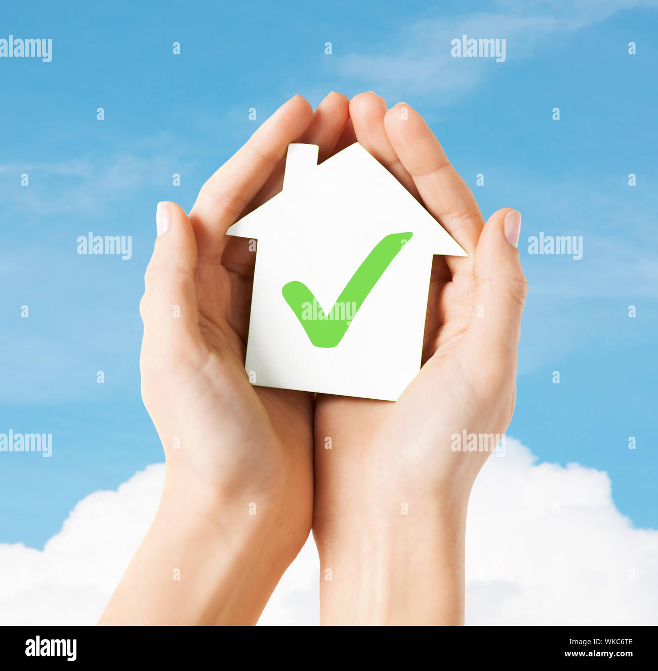 hands holding house with check mark Stock Photo