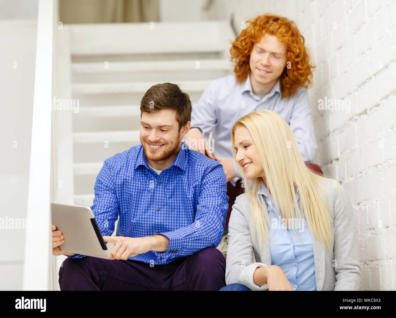 team with tablet pc computer sitting on staircase Stock Photo