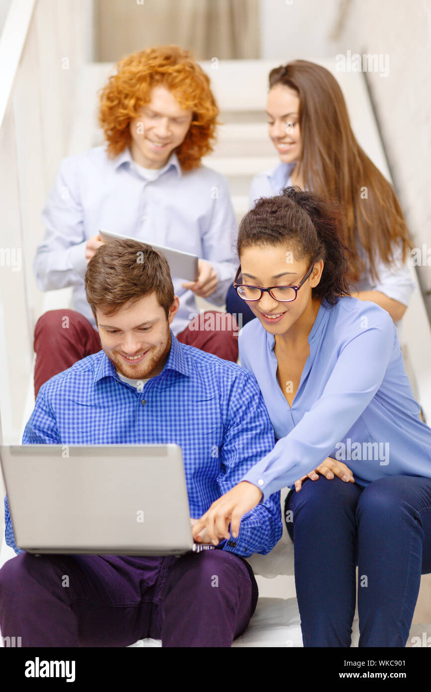 team with laptop and tablet pc on staircase Stock Photo