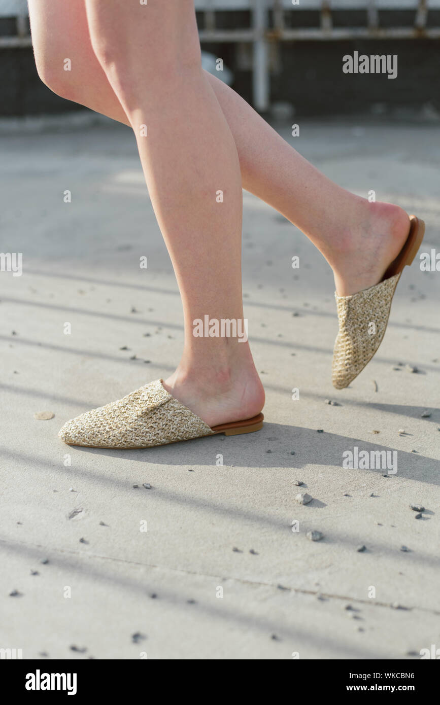 wicker beige mules on the girl s leg. The latest fashion trend Stock Photo  - Alamy