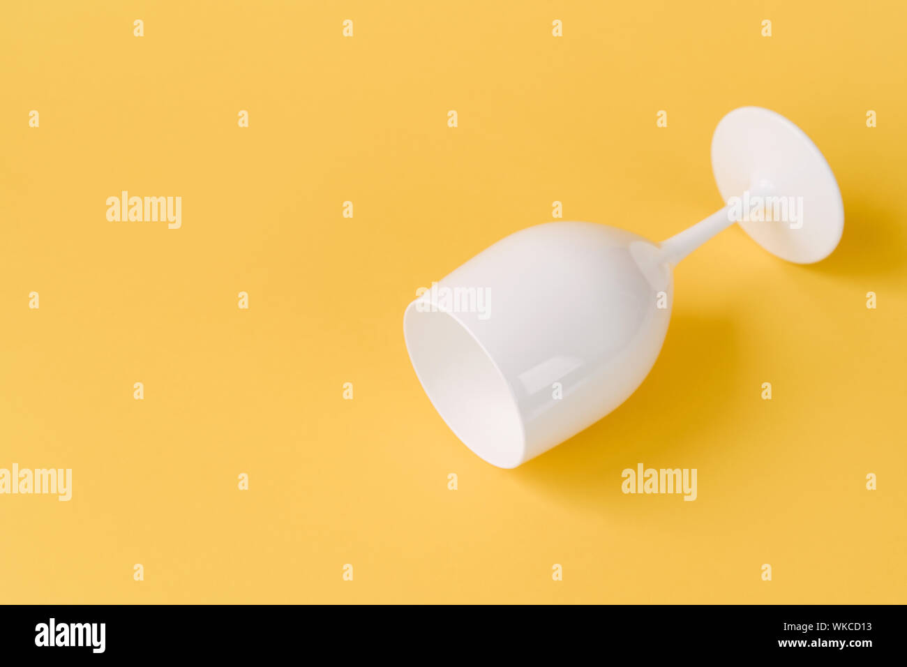 Creative festive white glass on a yellow background. Stock Photo