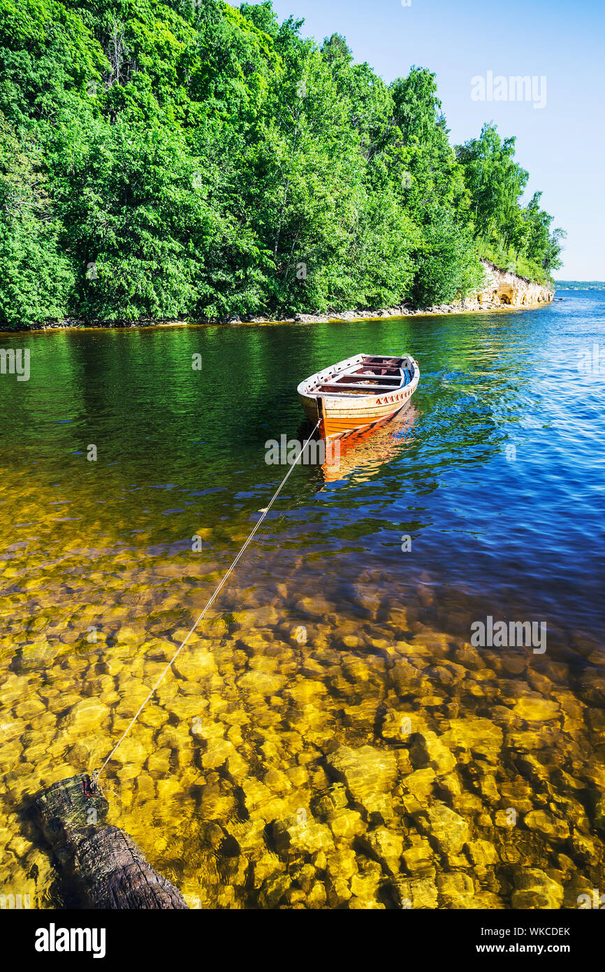 Wooden Boat On The River Bank On Forest Background And Blue Sky