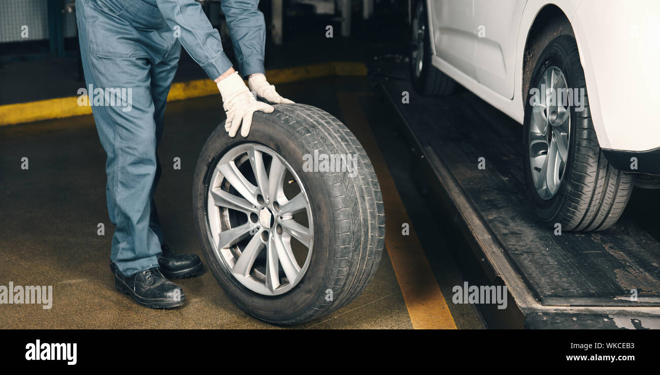 Mechatronics engineer changing tires in car in car workshop Stock Photo