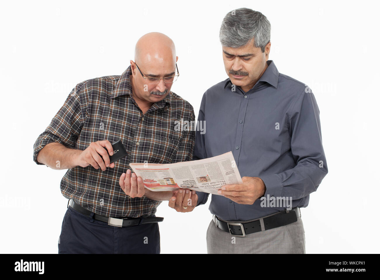 Two businessmen reading a newspaper Stock Photo