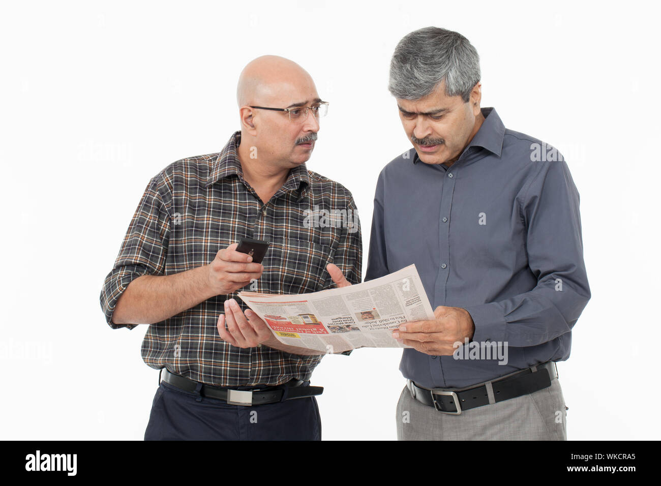 Two businessmen reading a newspaper Stock Photo