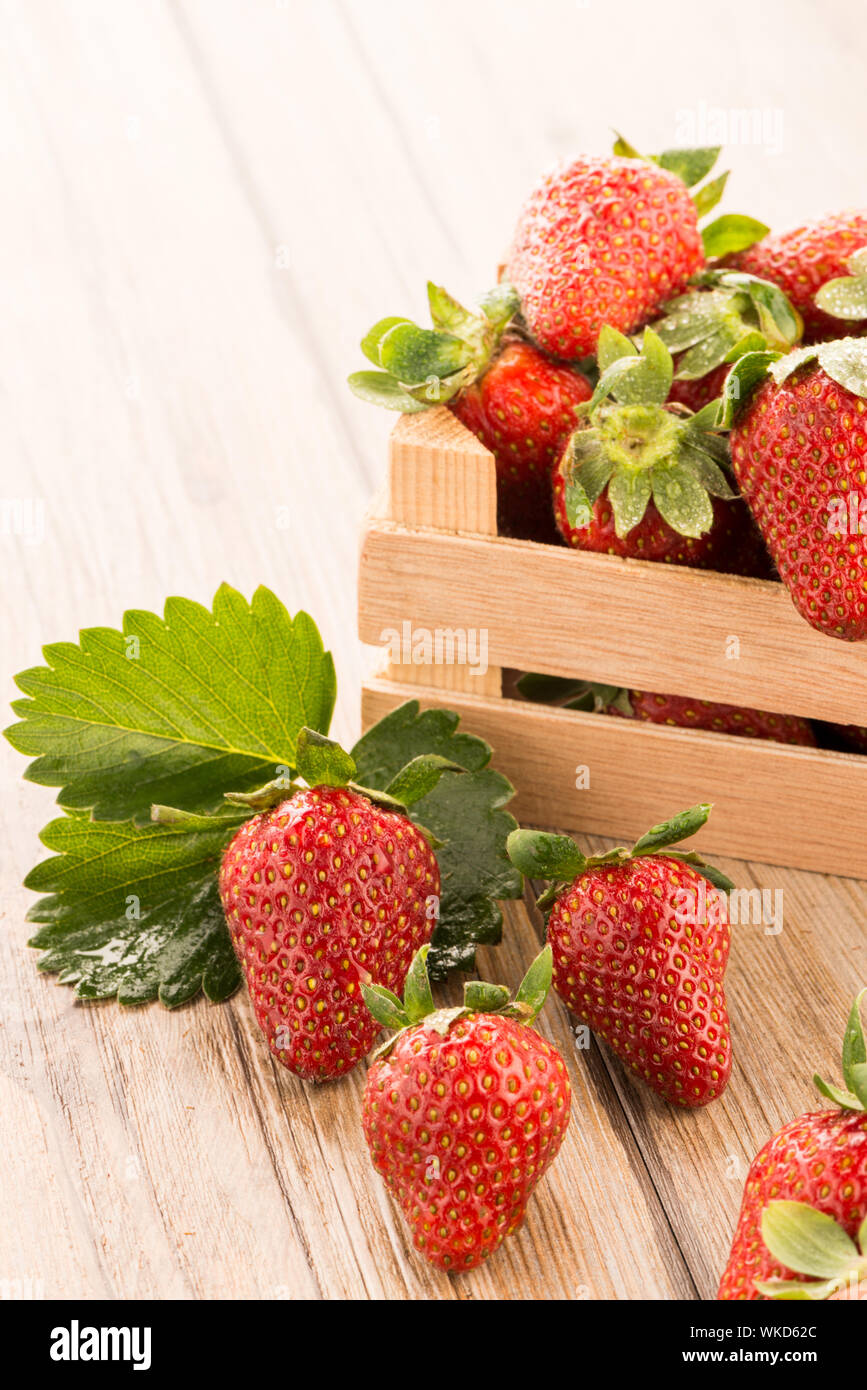 Strawberries over odl brown wooden table background Stock Photo - Alamy