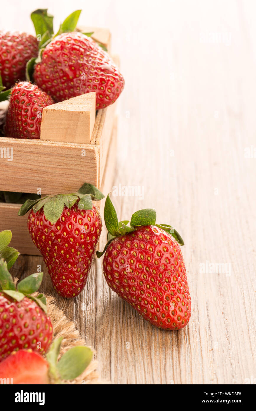 Strawberries over odl brown wooden table background Stock Photo - Alamy
