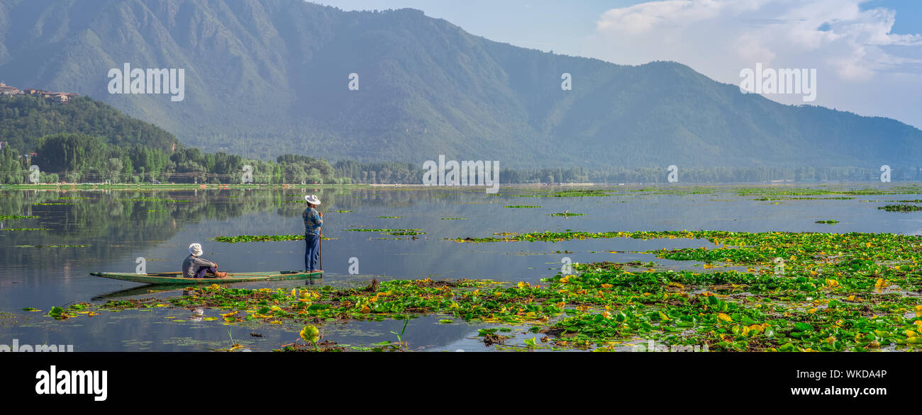 Two men fishing in a lake with mountains in the background on a early afternoon Stock Photo