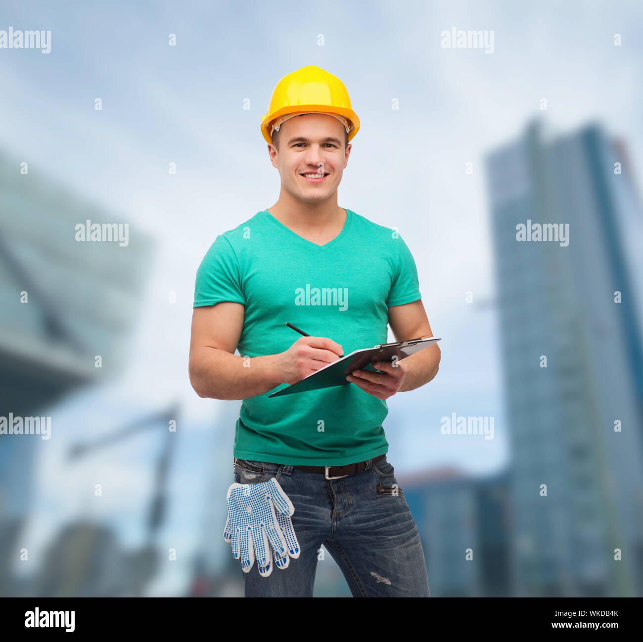 smiling man in helmet with clipboard Stock Photo