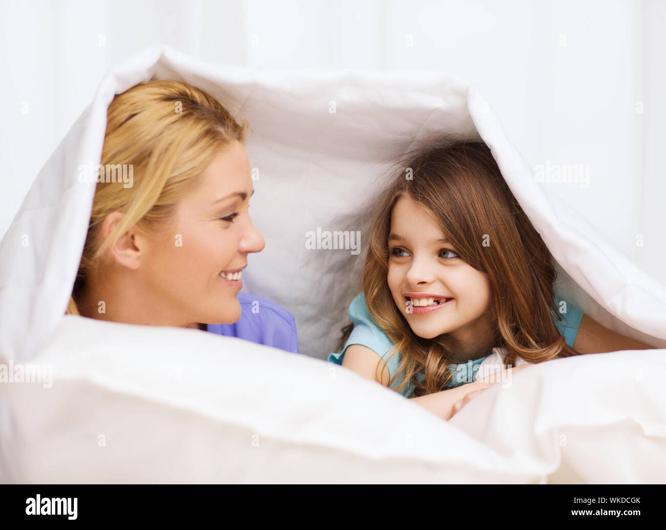 mother and little girl under blanket at home Stock Photo Alamy