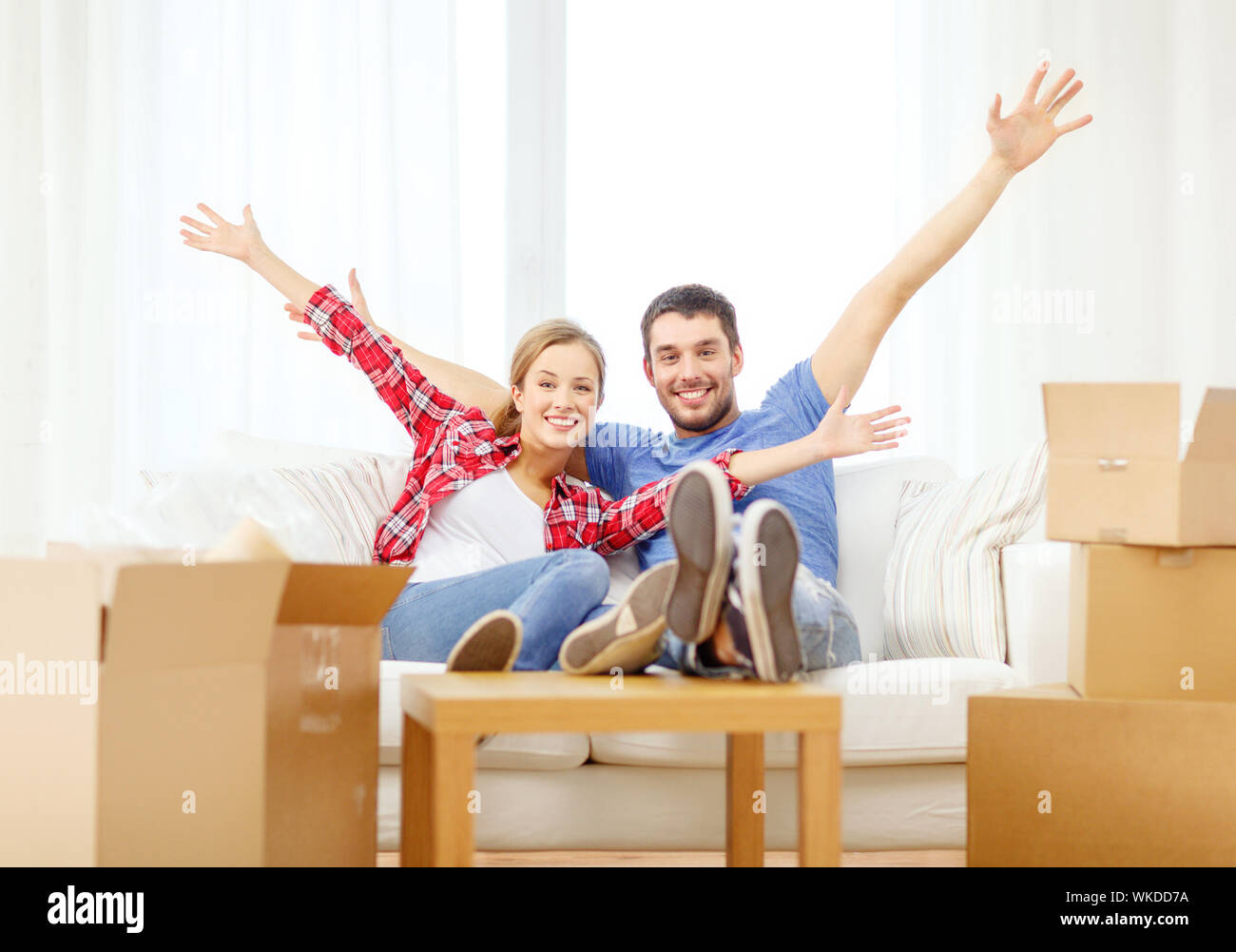 smiling couple relaxing on sofa in new home Stock Photo