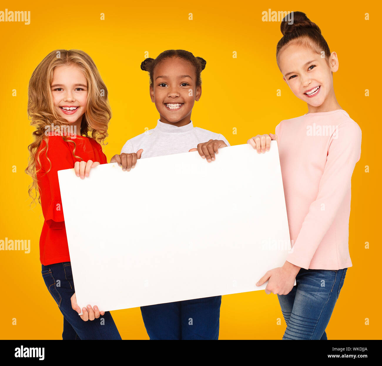 School girls holding blank paper banner for announcement Stock Photo