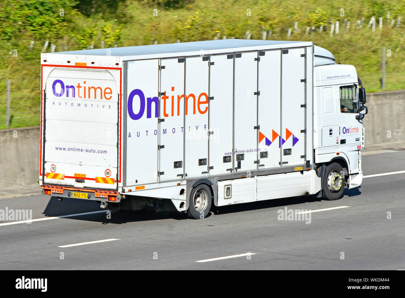 Back & side view of Ontime automotive transport business enclosed car delivery  operator hgv lorry truck with company logo driving along UK motorway Stock Photo