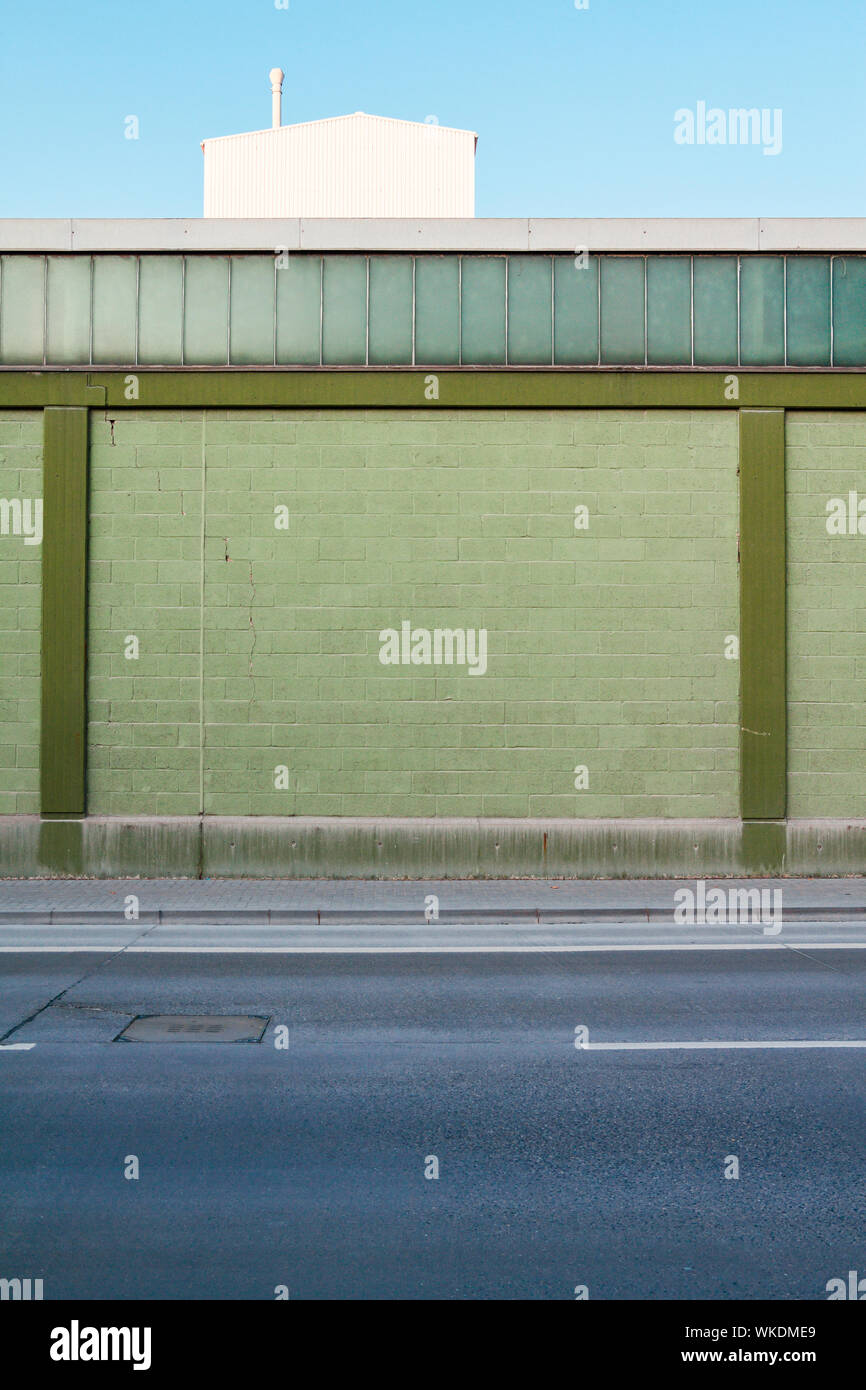 Empty Road By Green Wall Stock Photo - Alamy