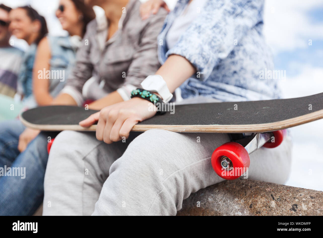 acticity and summer holiday concept - close up of female hand holding skateboard Stock Photo