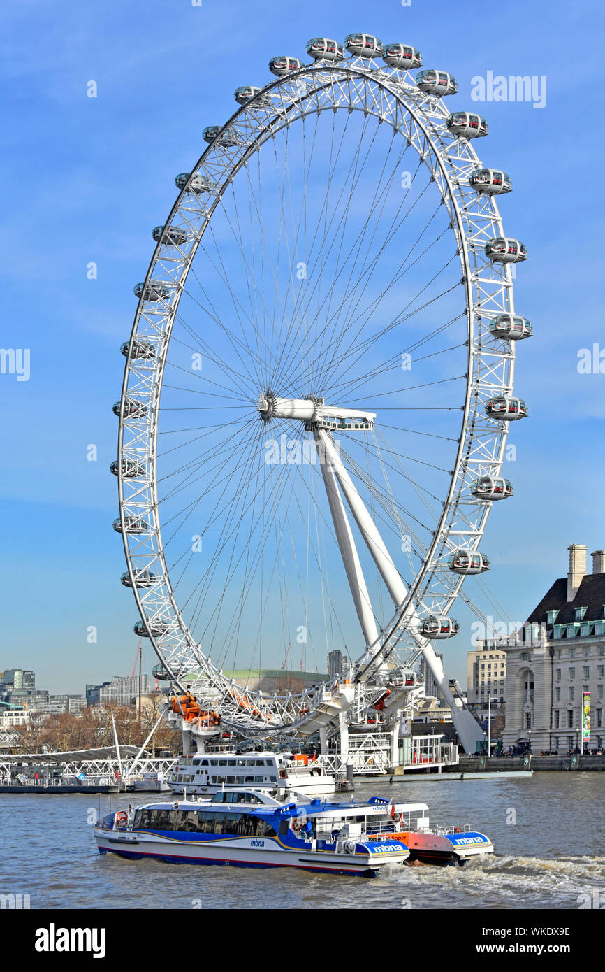 Stern & side view of high speed River Thames Clipper catamaran public transport fast river bus with iconic London Eye landmark ferris wheel England UK Stock Photo