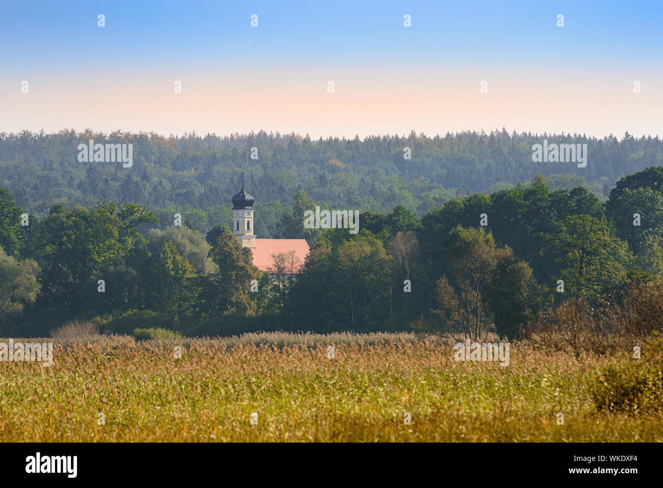 Upper Bavarian autumn landscape with small church in morning mist forest near lake Starnberger See Stock Photo