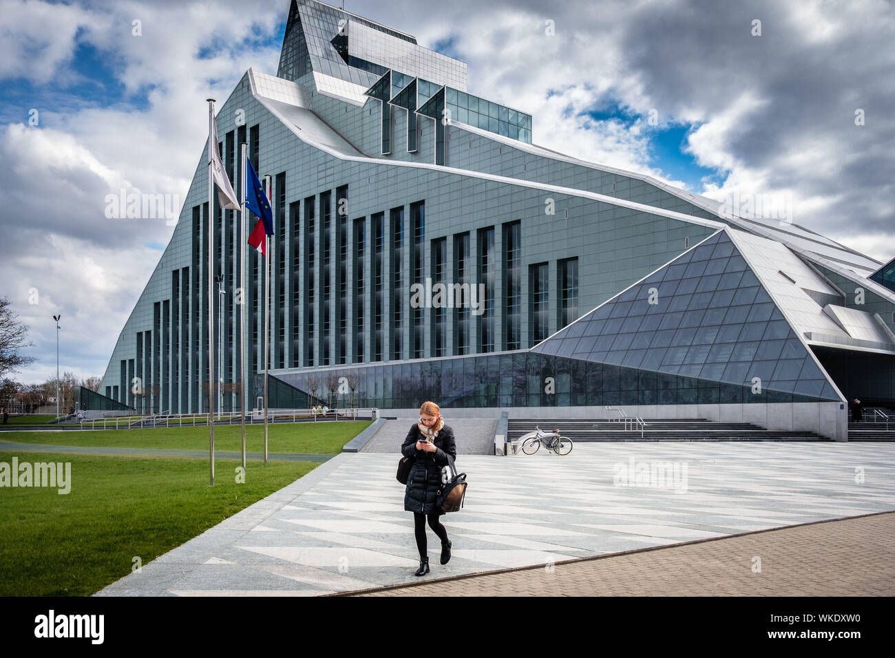 Latvia, Riga. The National library, 13-storey glass and metal building, with a collection of 6 million books, on the banks of the Dauvaga river. Woman Stock Photo