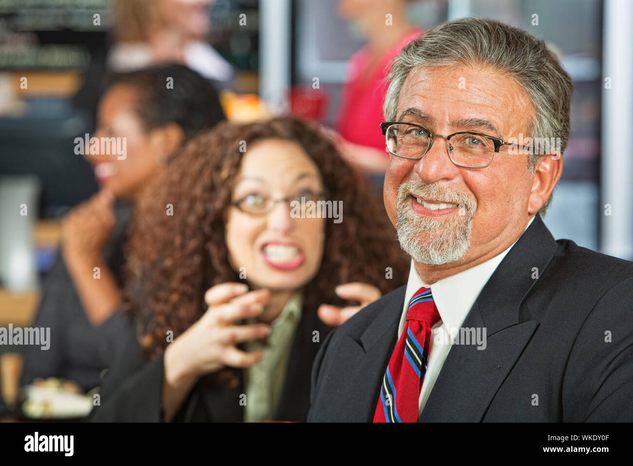 Angry woman trying to strangle naive businessman Stock Photo