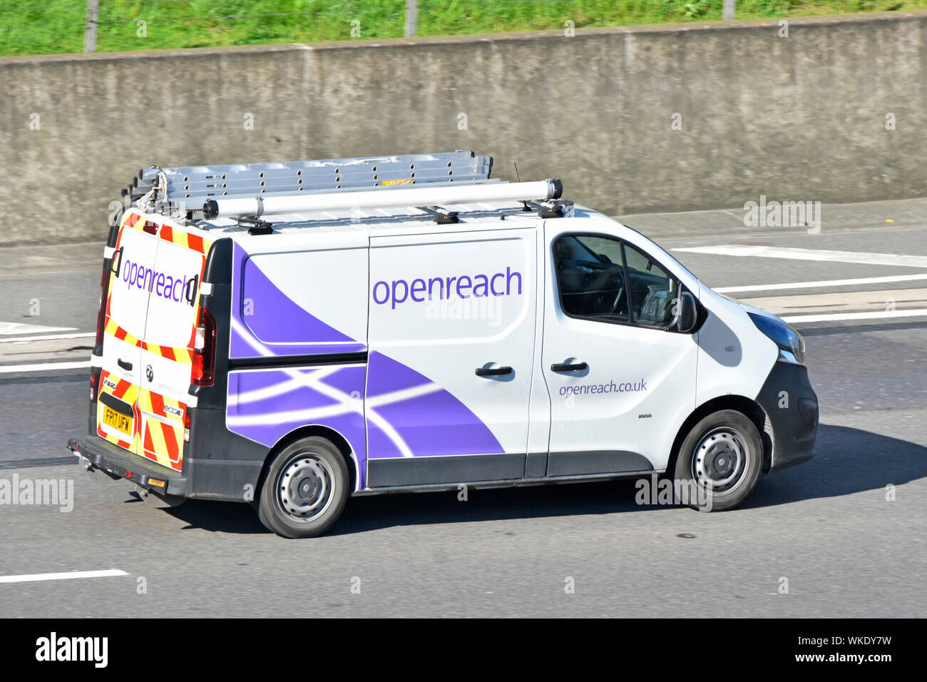 View from above of side of openreach van & driver with roof rack for ladders a subsidiary of BT Telecommunications business driving along UK motorway Stock Photo