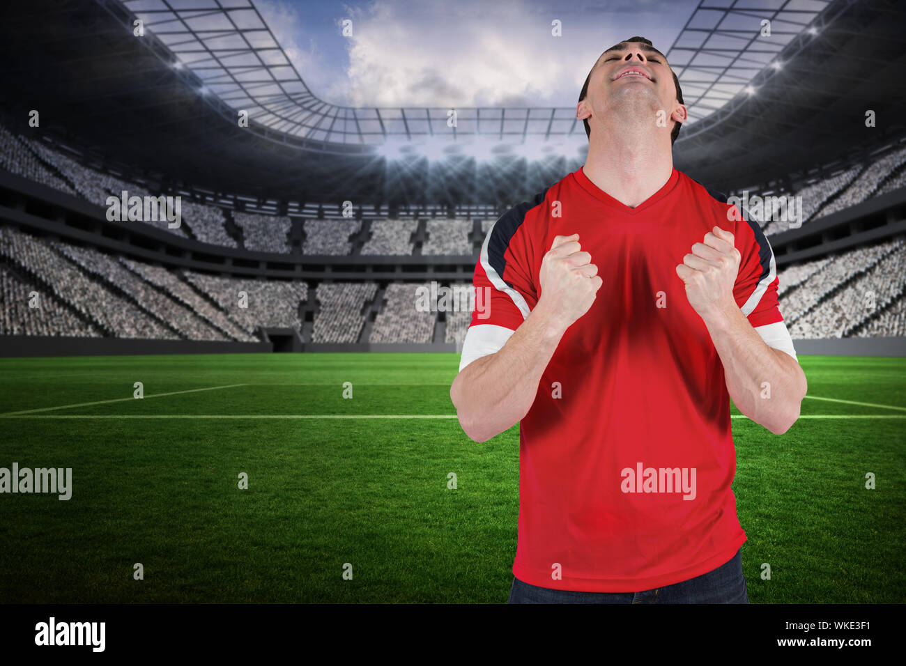 Excited football fan cheering in a vast football stadium with fans in