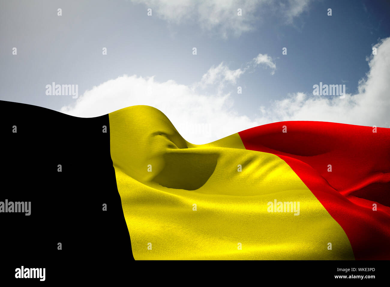 Belgium flag waving against bright blue sky with clouds Stock Photo