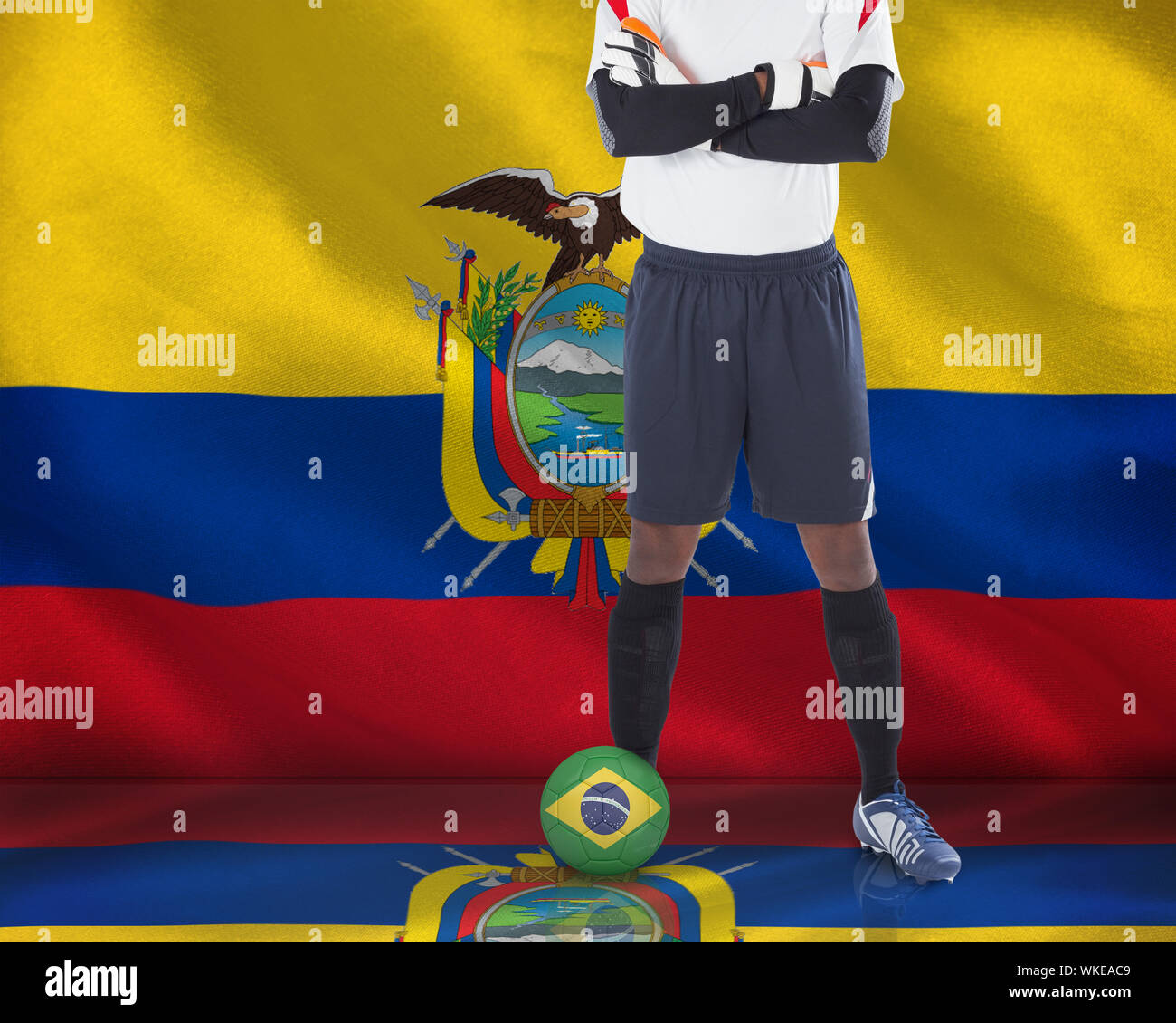 Composite image of football player standing with ball against digitally generated ecuador national flag Stock Photo