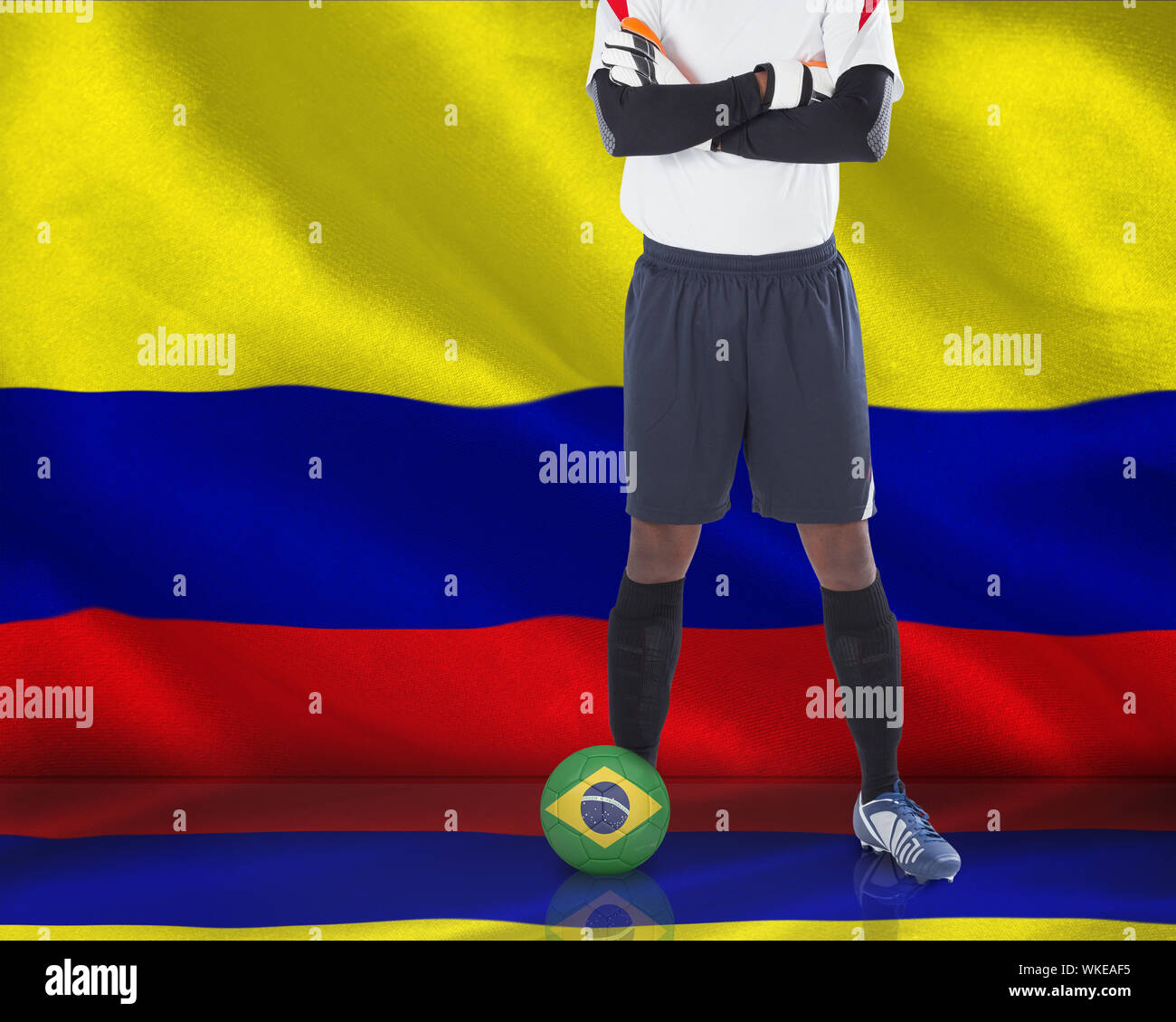 Composite image of goalkeeper in white with ball against digitally generated colombia national flag Stock Photo