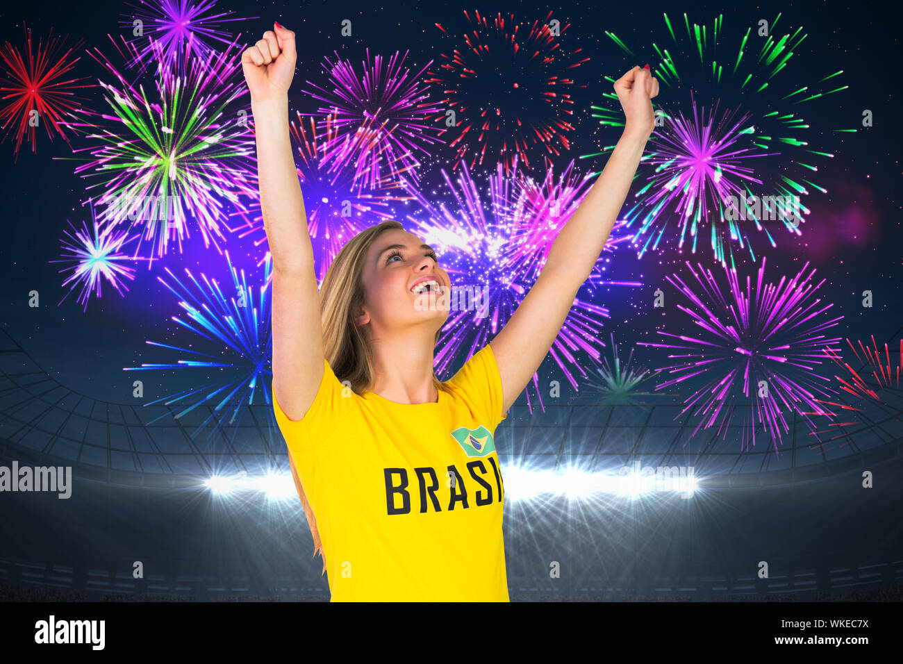Excited football fan in brasil tshirt against fireworks exploding over ...