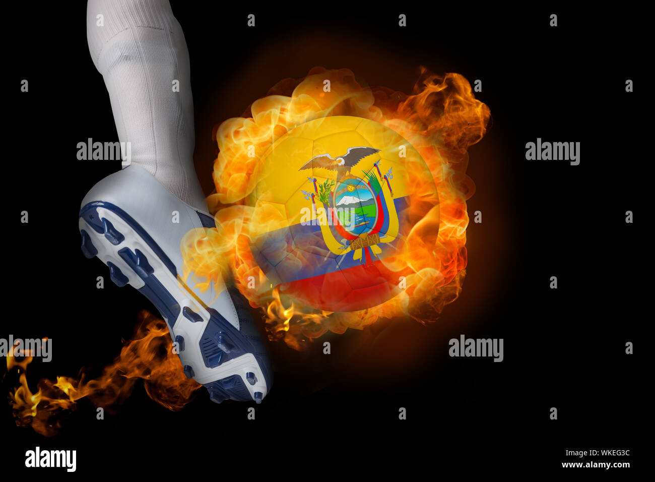 Football player kicking flaming ecuador ball against black Stock Photo