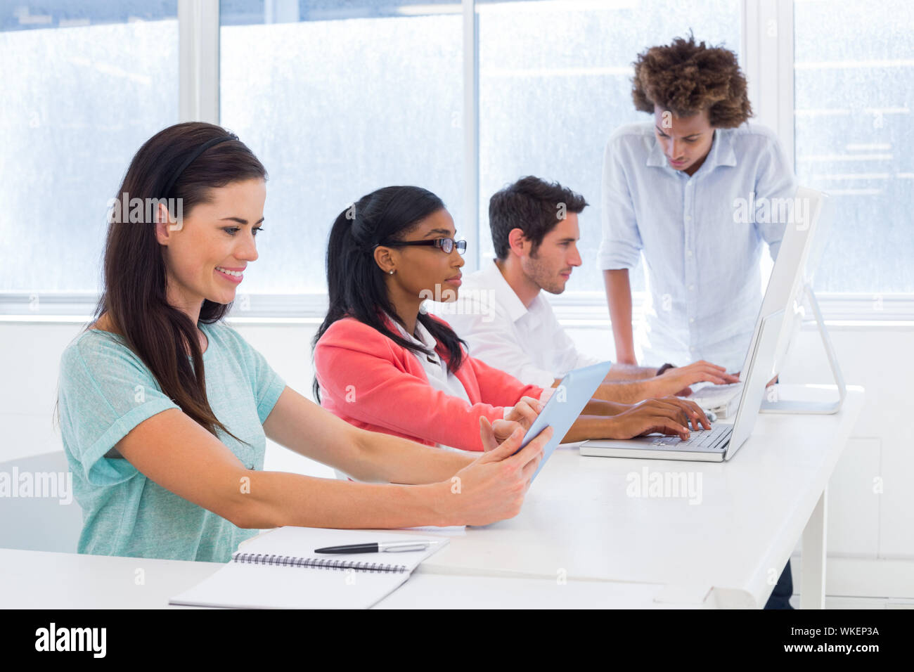 Workers on tablets and laptops in the office Stock Photo