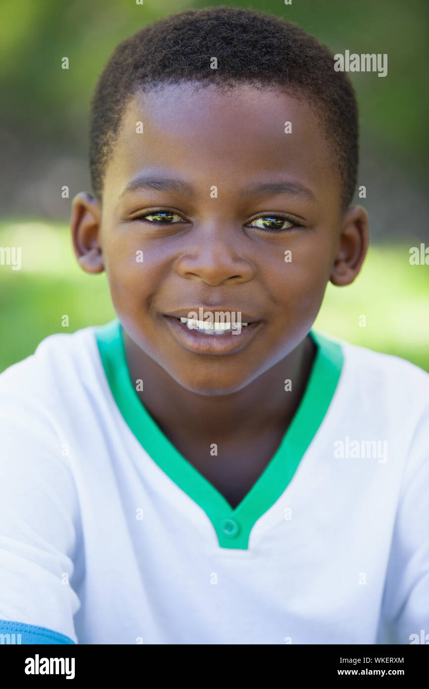 Cute boy smiling at the camera in the park on a sunny day Stock Photo ...