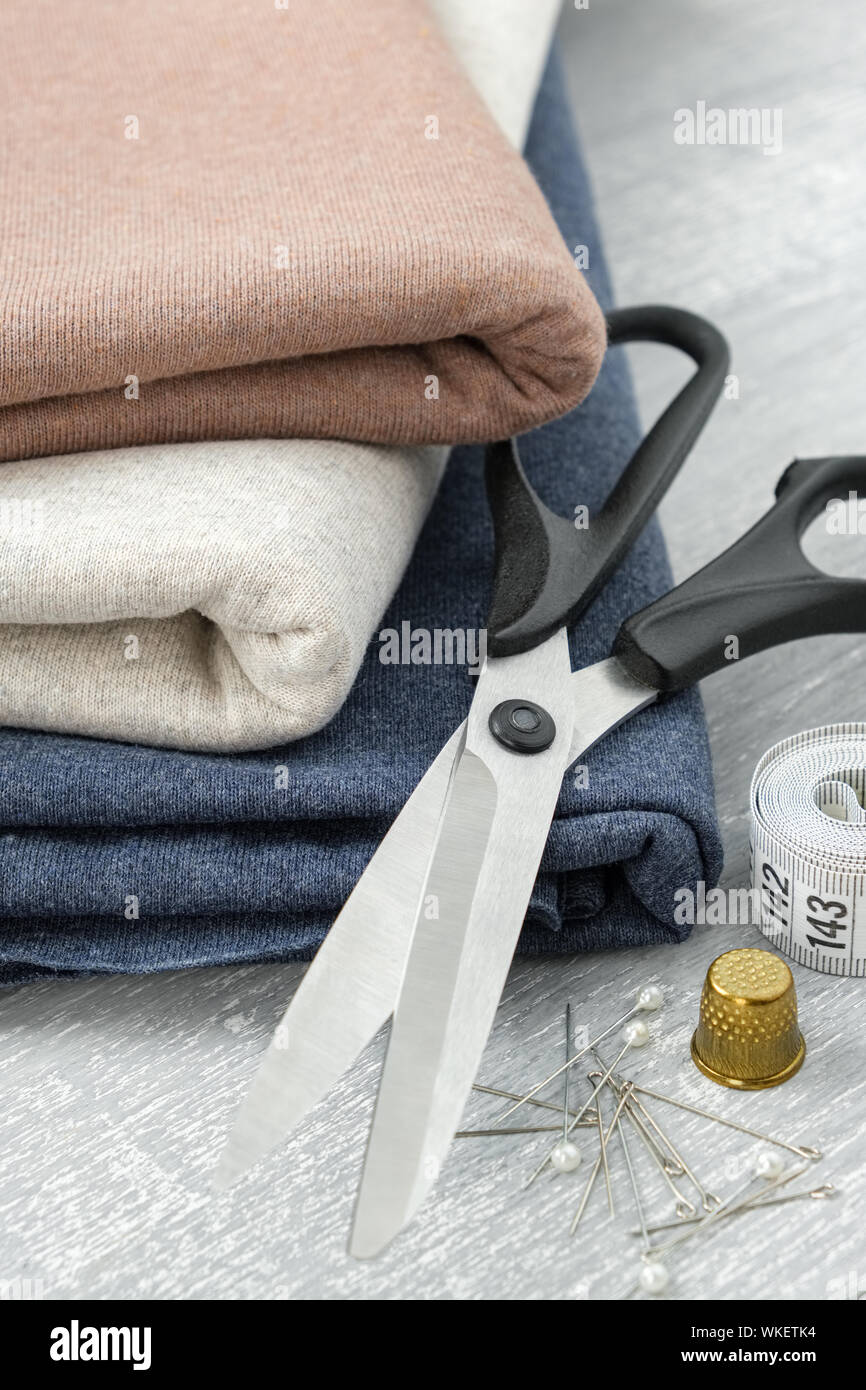 Sewing items: fabrics, tailoring scissors, tape measure for sewing clothes. Stock Photo