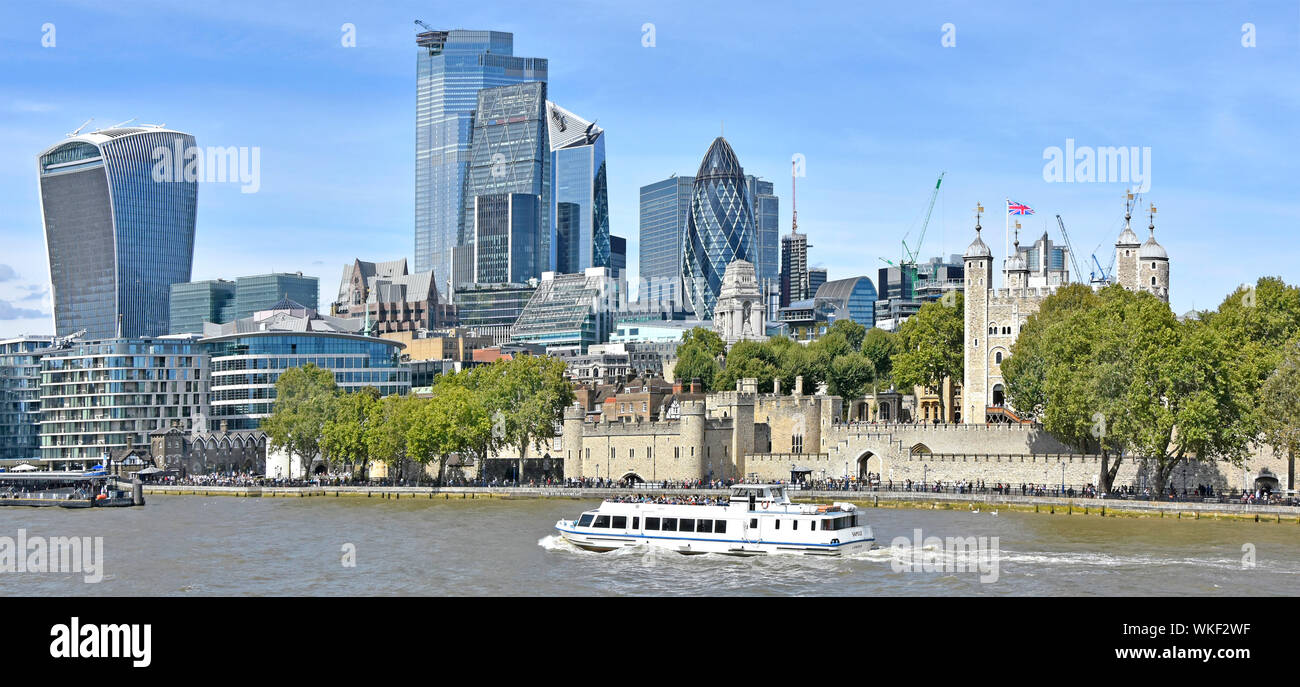 Sightseeing boat & River Thames at Tower of London views of skyline cityscape of skyscraper buildings 2019 in city square mile business district UK Stock Photo