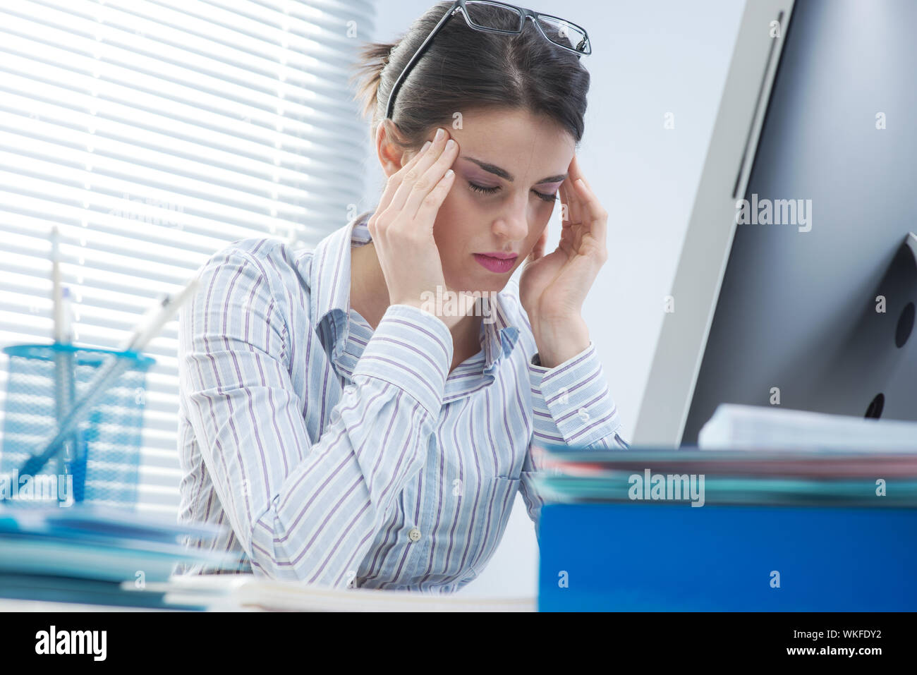Tired office worker with headache touching her temples Stock Photo - Alamy