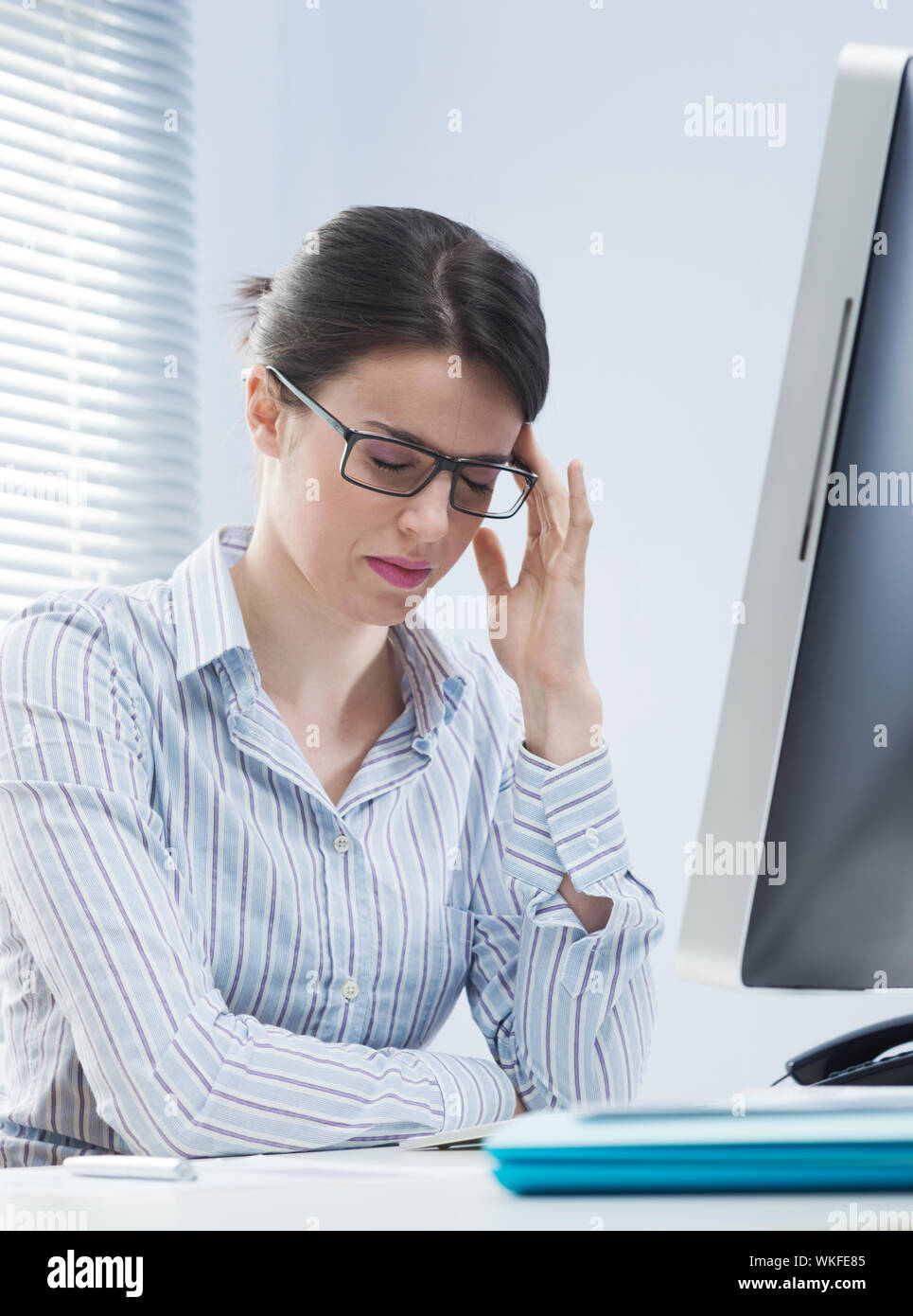 Tired office worker with headache touching her temples Stock Photo - Alamy